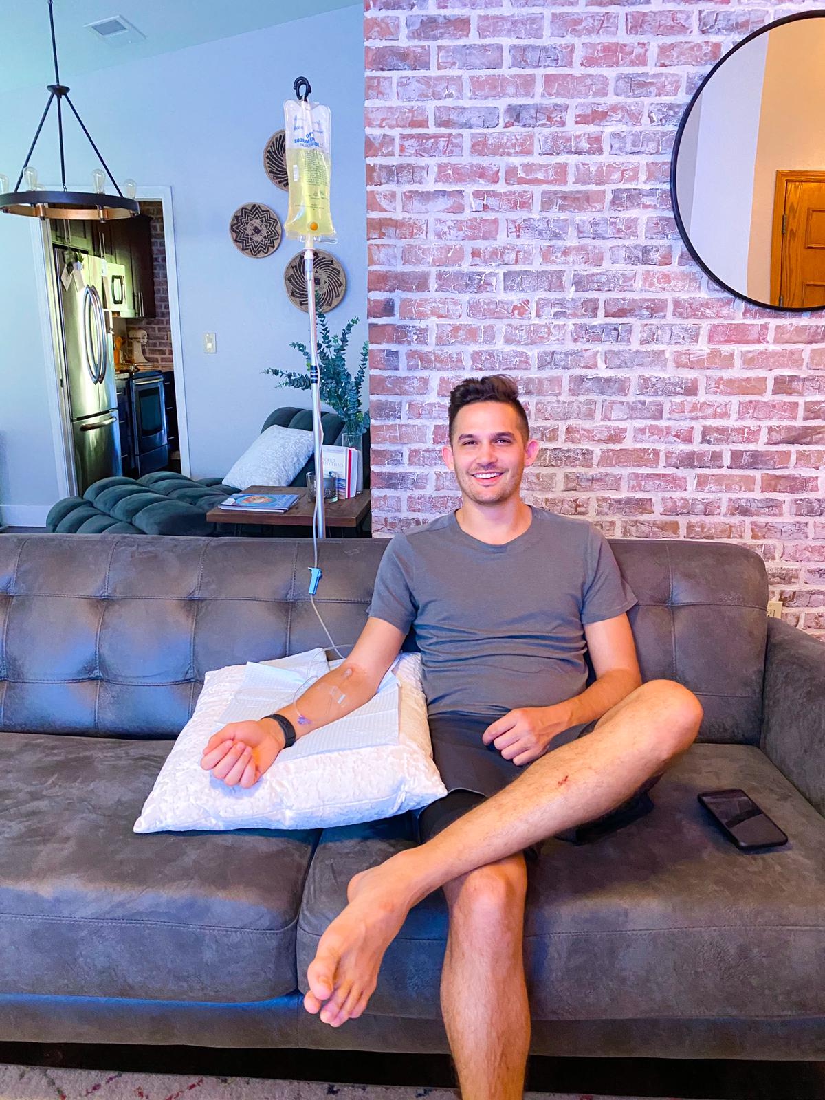 Man receiving mobile IV therapy at home in Kailua-Kona, Hawaii, seated on a couch